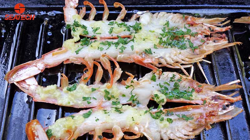 A photograph of whole split argentine red shirmp grilled with garlic butter and parsley.